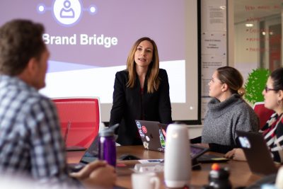 Female business leader addresses room of employees room